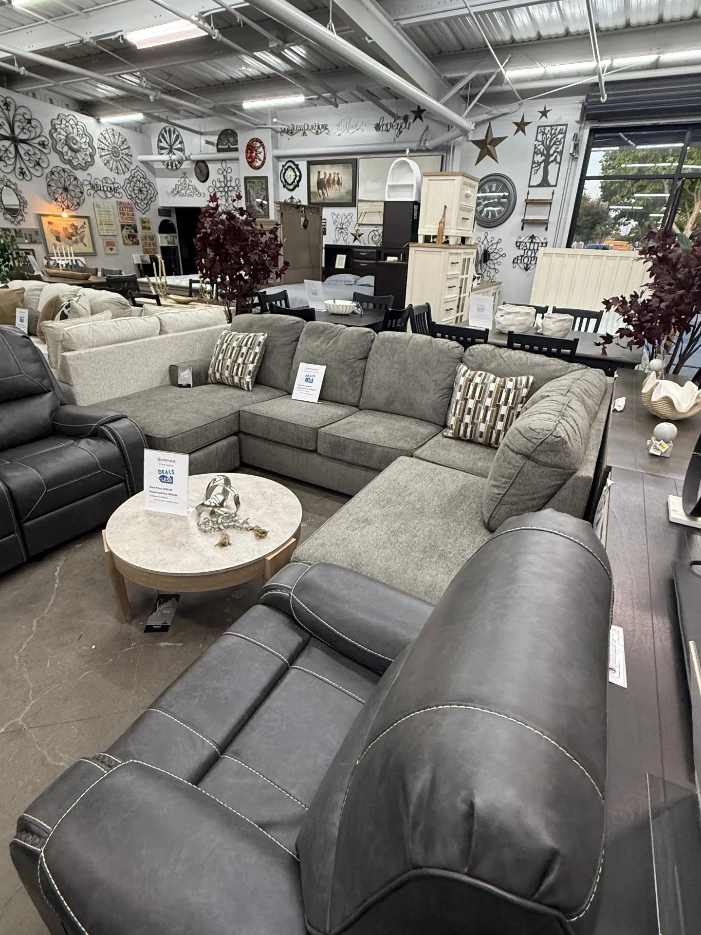 Gray U-shaped sectional with leather recliner and wall decor at Deals4Less Spruce