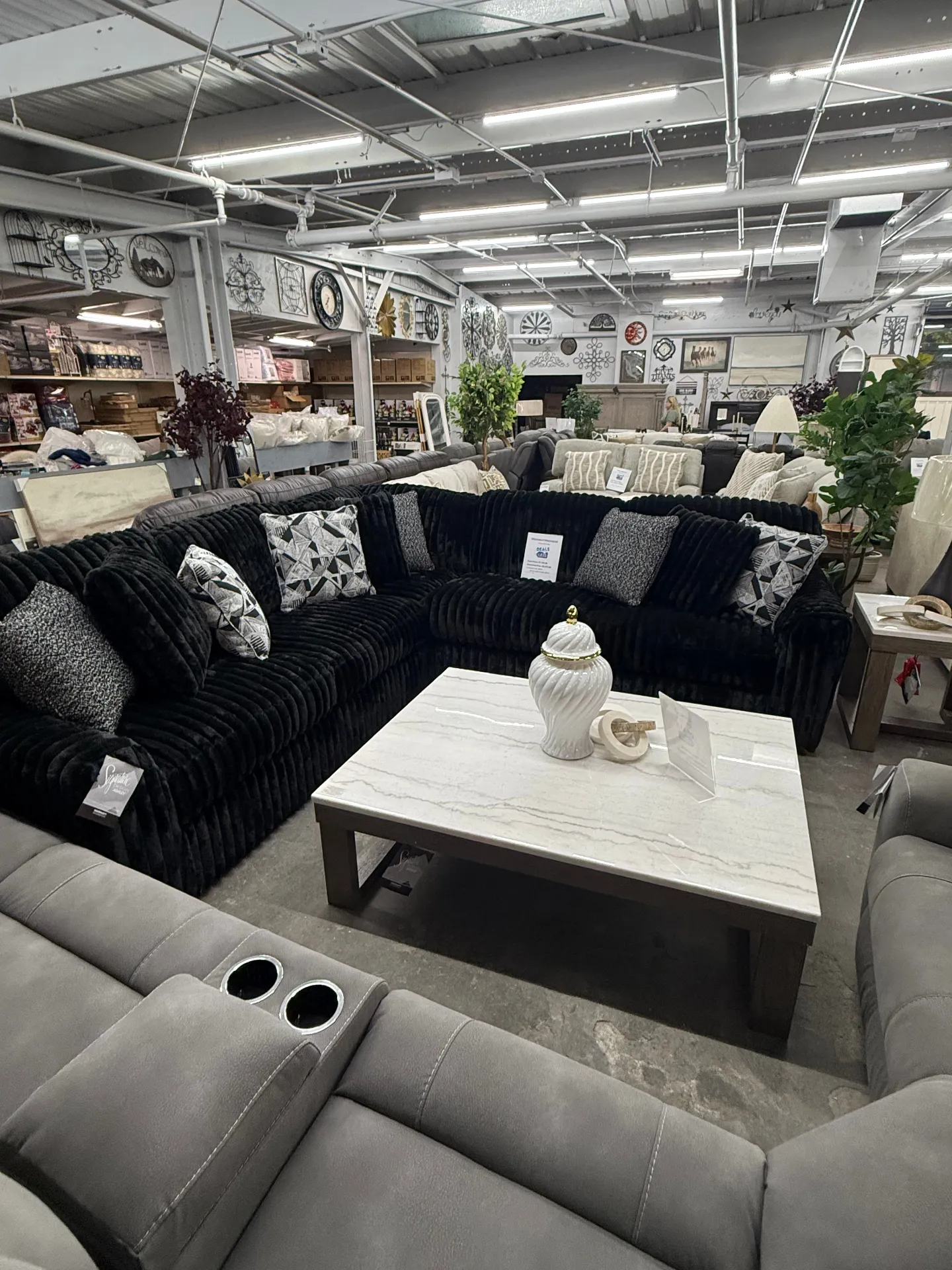 Black plush sectional and home decor at Deals4Less Spruce