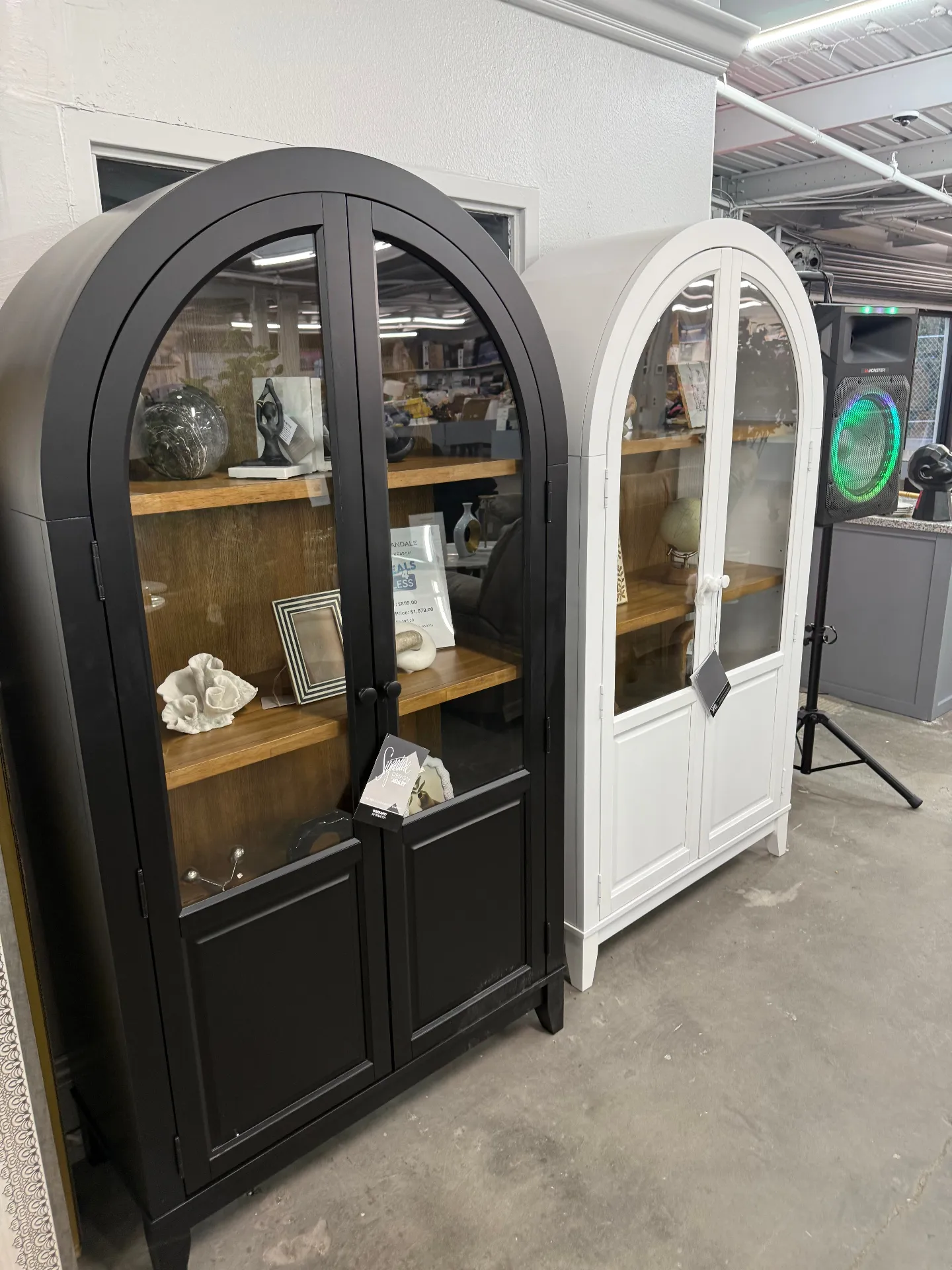 Black and white arched display cabinets at Deals4Less Spruce