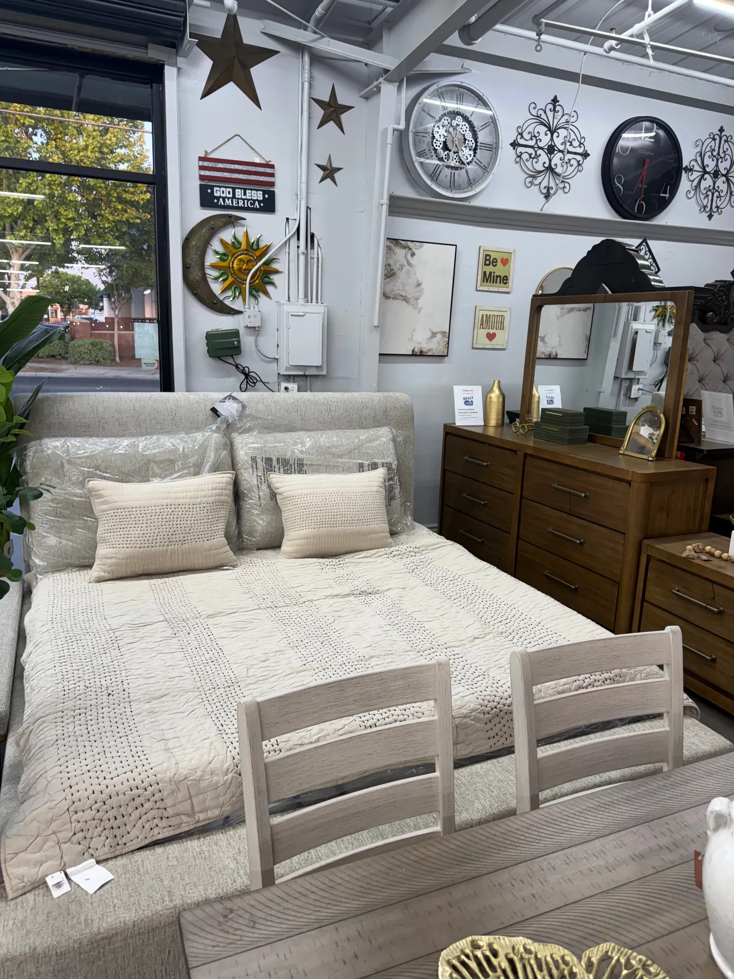Light upholstered bed with wood dresser and mirror at Deals4Less Spruce